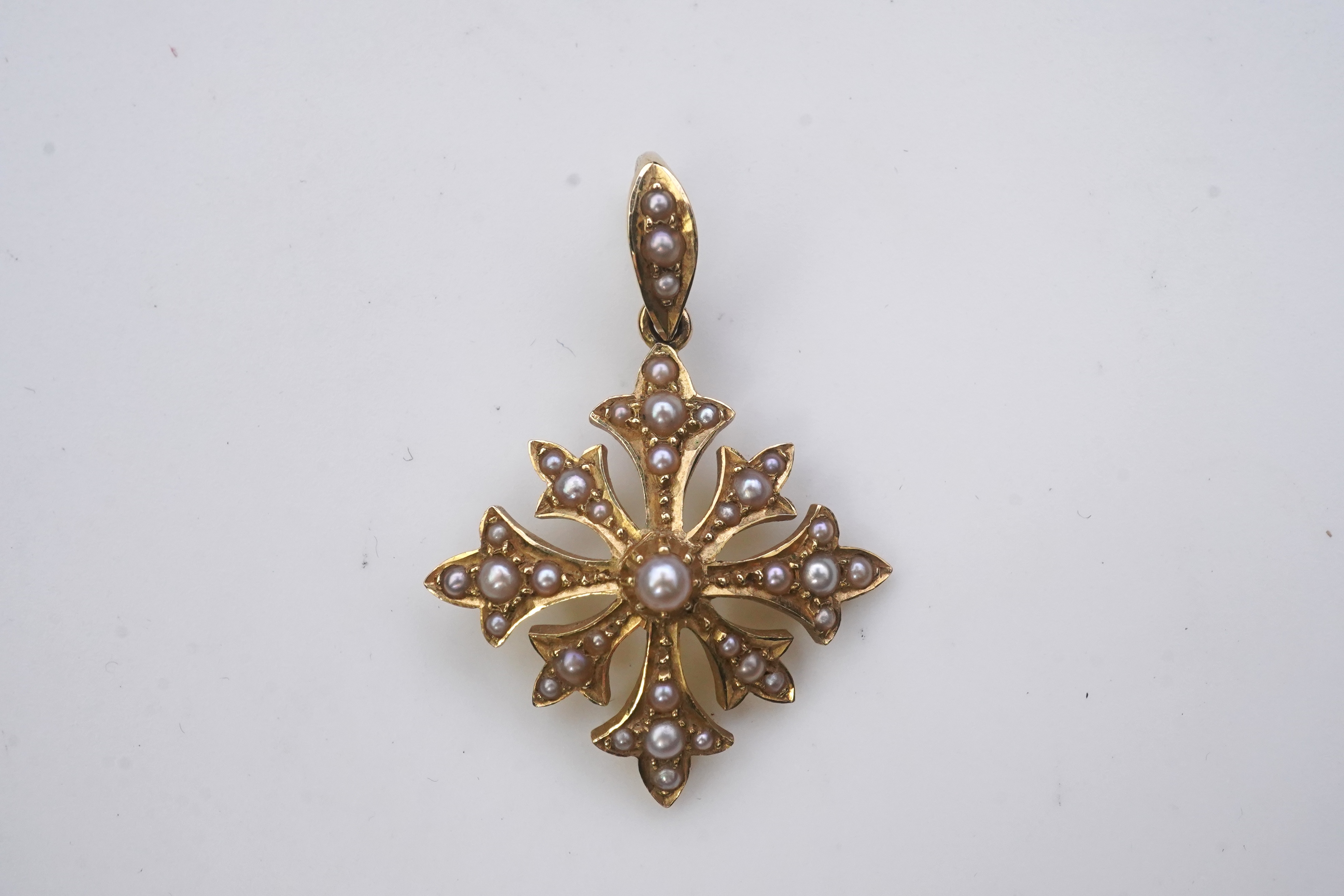 A Georgian mourning brooch, early 19th century, two Edwardian pendants, early 20th century